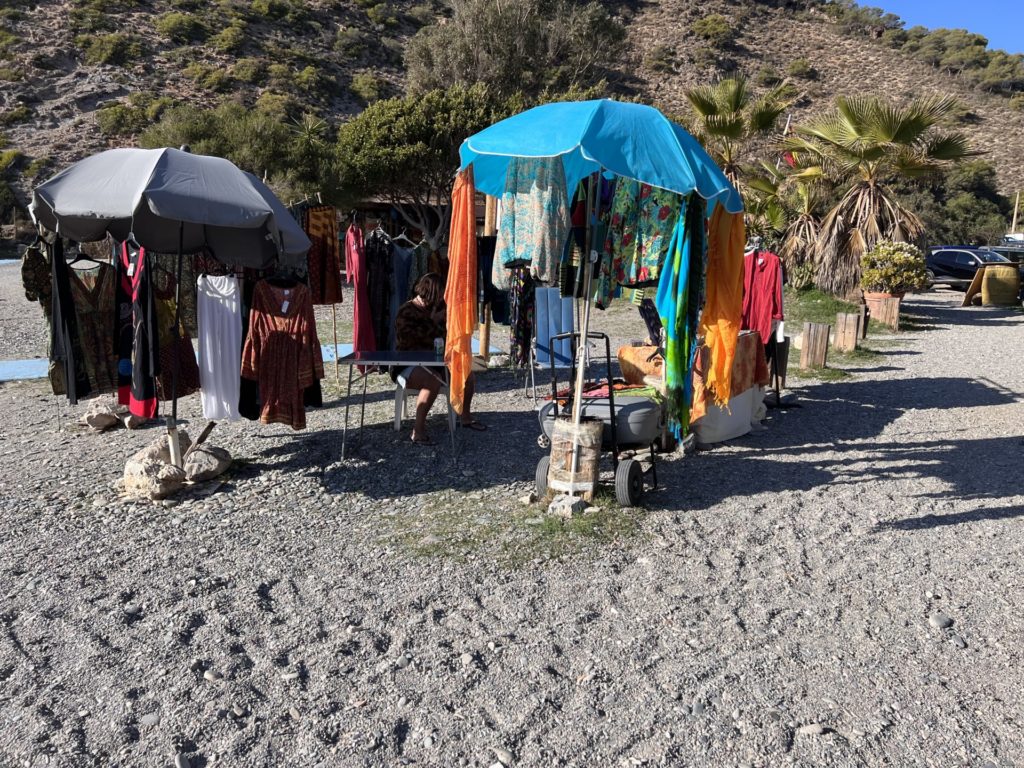 Coloured Boho clothes on a sellers stall, billowing in the wind in the wind on Playa Cantarrijan in Andalucia