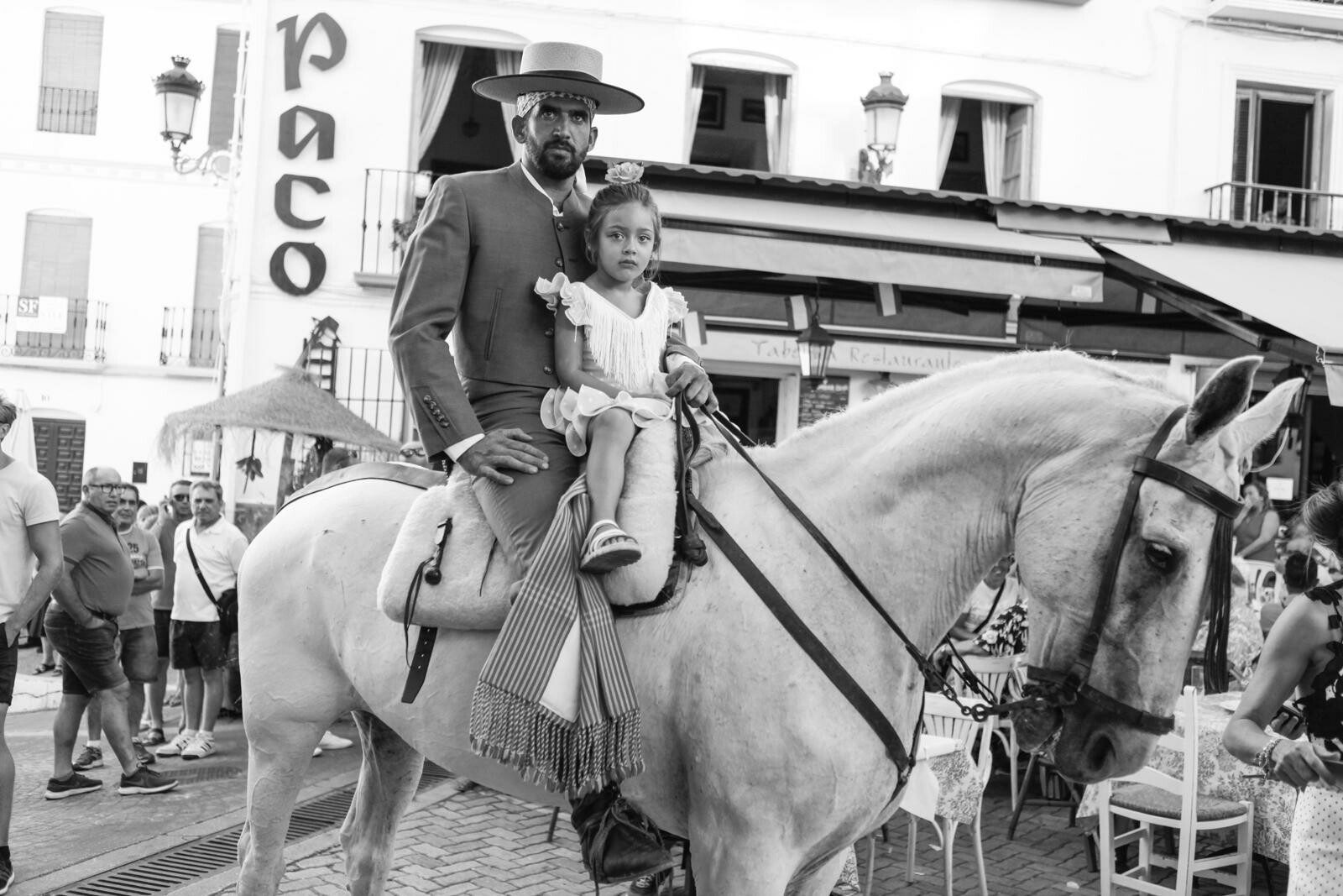 Photo shows Andalucian rider on horse with his daughter at the Competa Feria 2022