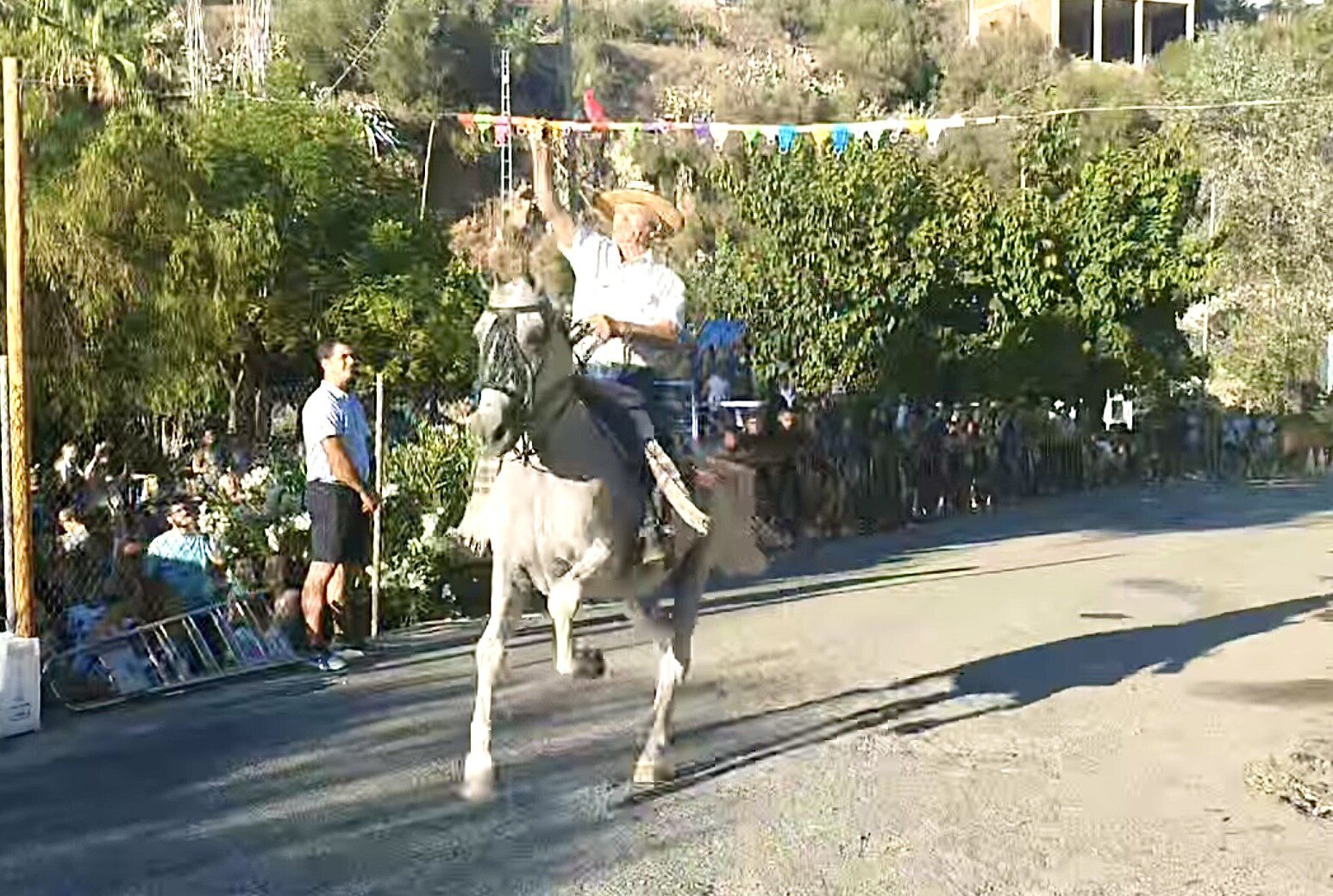 This image shows a horseman competing in the Corrida de Cintas at Competa Summer Feria