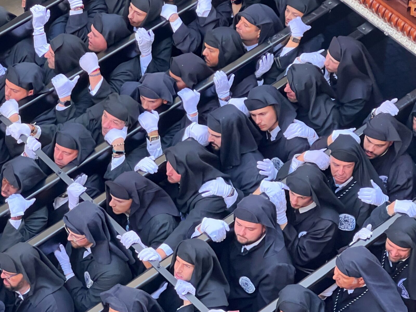 This image is a close up of the bearers resting, their faces clearly showing the exertion required to carry the tronos through the streets of Malaga during Semana Santa